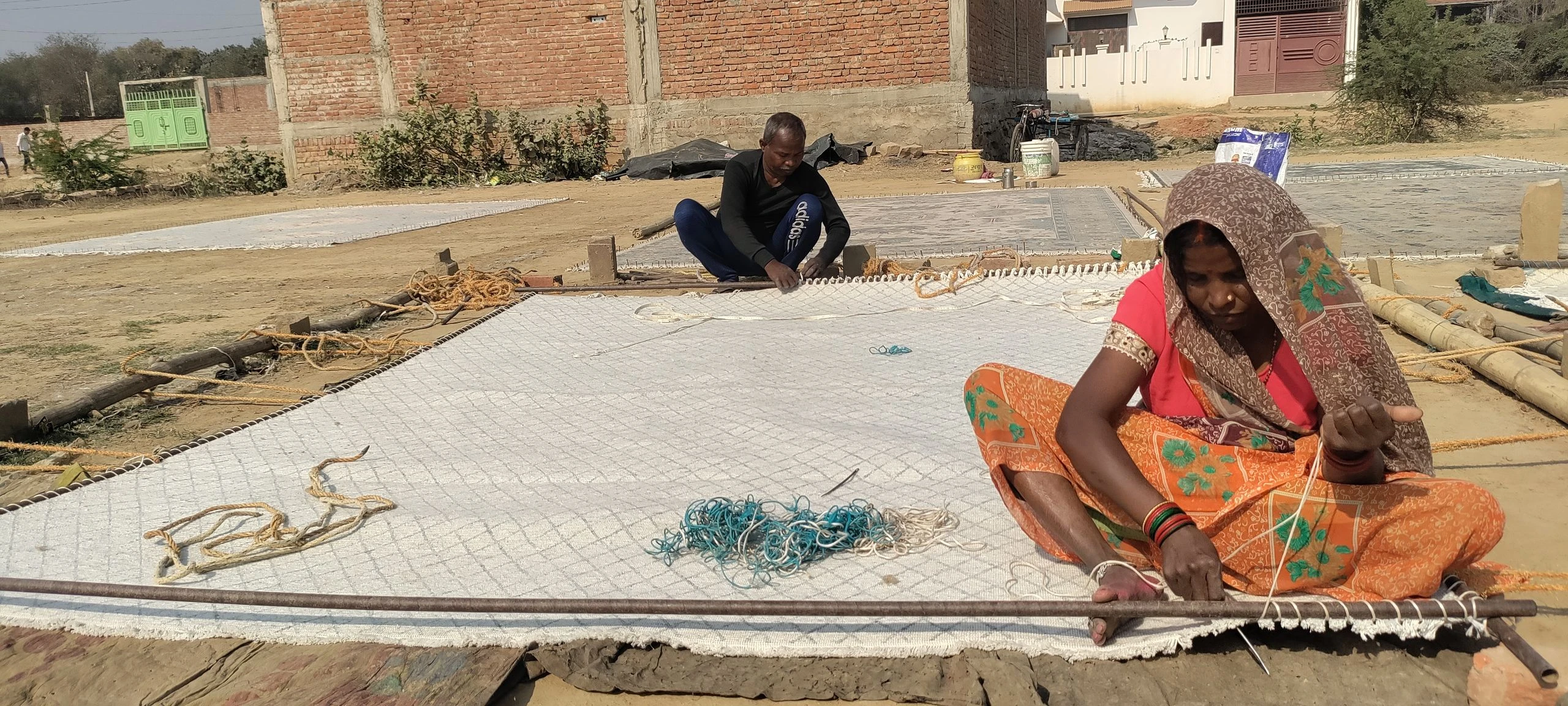 Artisans hand serging the border of a custom Kaleen wool rug.