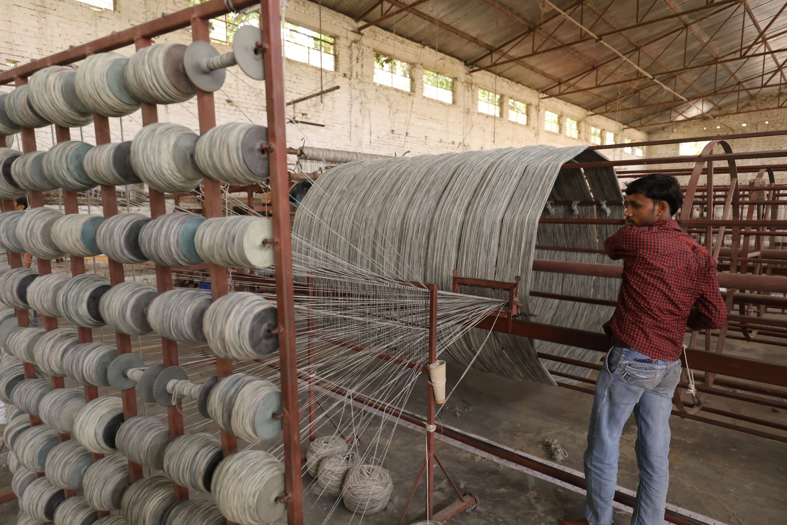 Image of wool loaded on multiple spools to weave into carpets in the Kaleen production facility in India