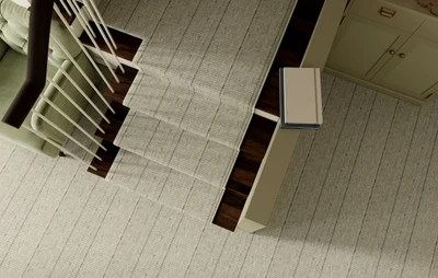  Up close view of a stunning dark brown wood staircase accented with a light khaki broadloom with brown vertical stripe from Kaleen.