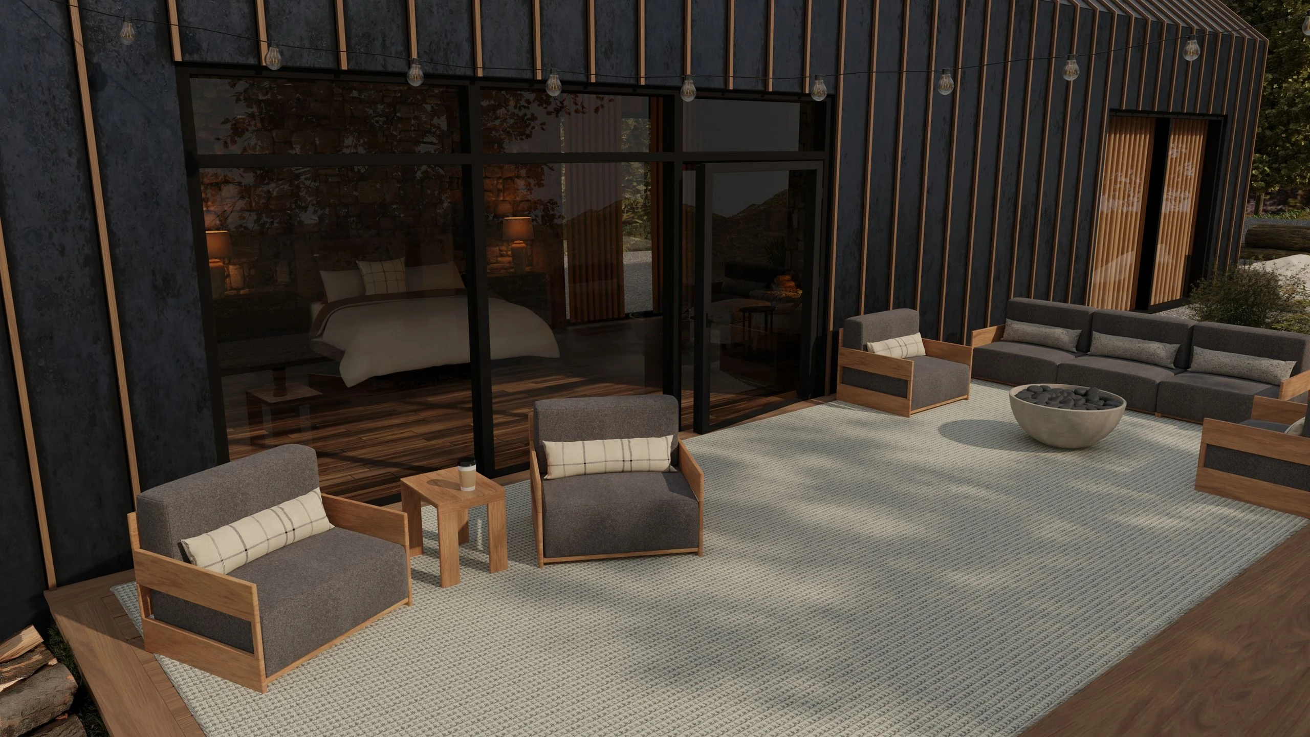 Outdoor patio with gray lounge seating on a King & Prince flatweave rug beside a modern dark-clad home
