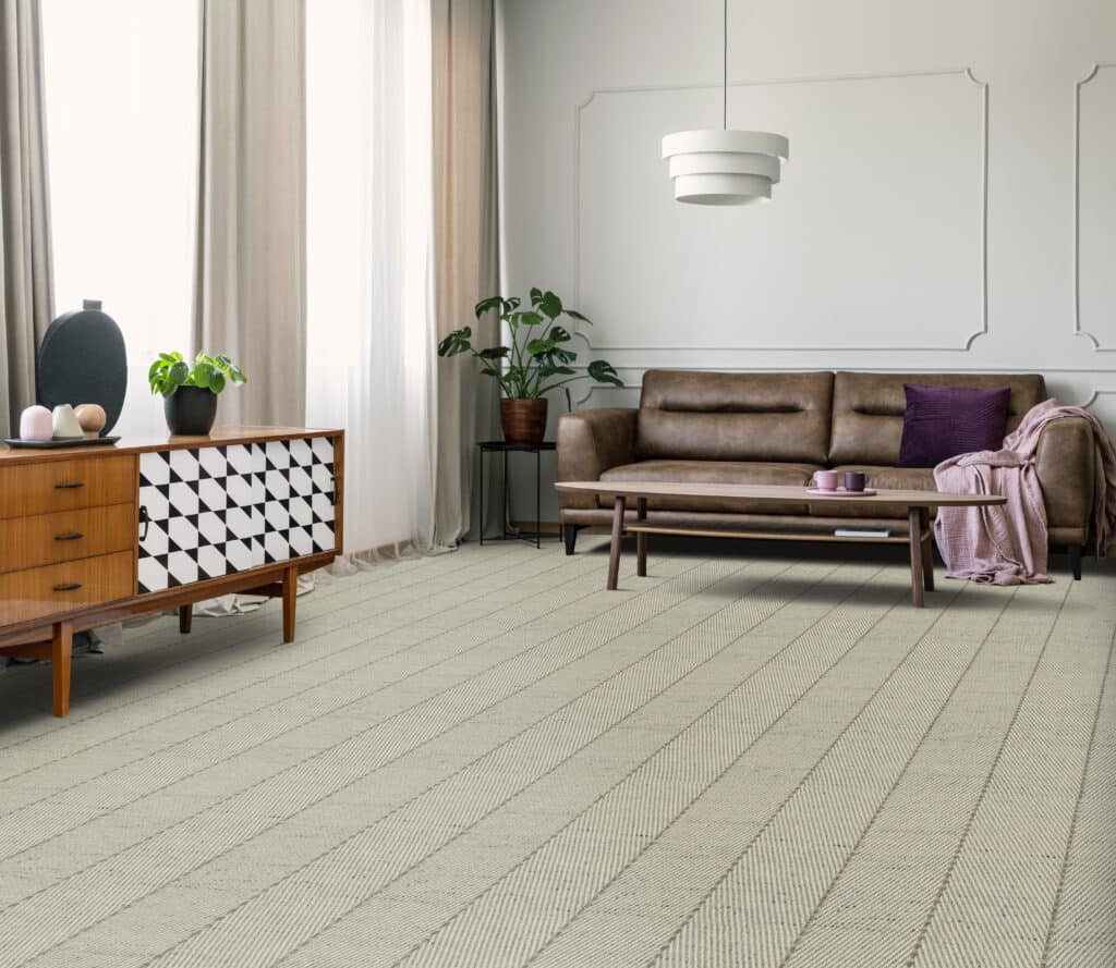 Martinique grey wool carpet with chevron pattern in a room with a brown sofa